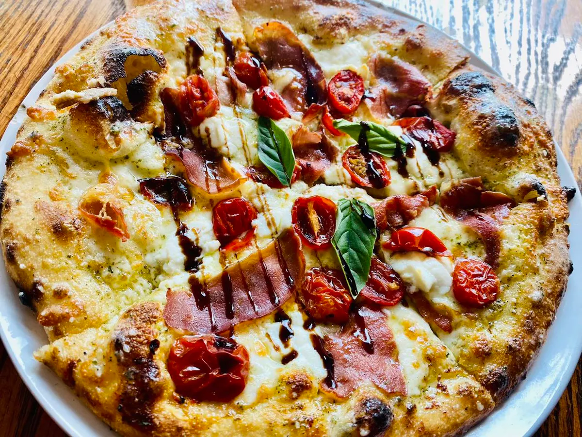 a pizza sitting on top of a wooden table